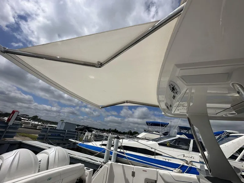 Slide: The Image of 2024 Regal 38SAV boat with extended sunshade at marina. - 5