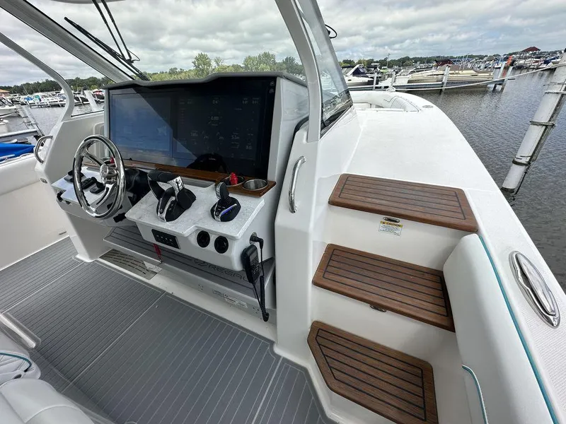 Slide: The Image of 2024 Regal 38SAV boat helm with modern controls and wooden steps. - 7
