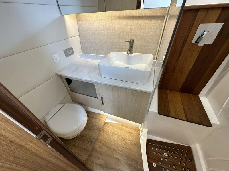 Slide: The Image of Modern bathroom in 2024 Regal 38SAV boat with sink, toilet, and wooden shower area. - 9