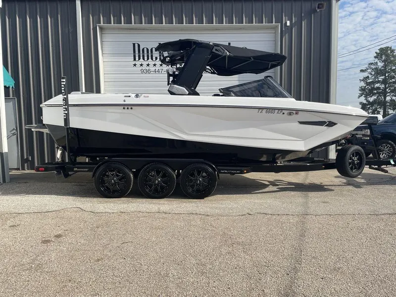 Slide: The Image of 2022 Nautique Super Air Nautique G23 boat on a trailer outside a building. - 0