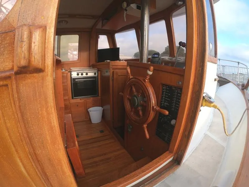 Slide: The Image of 1977 CHB 34 Double Cabin boat interior with wooden helm and kitchen area. - 17