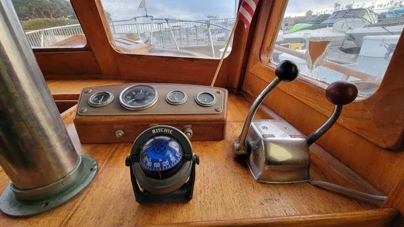 Slide: The Image of 1977 CHB 34 Double Cabin boat helm with compass, gauges, and throttle controls. - 18