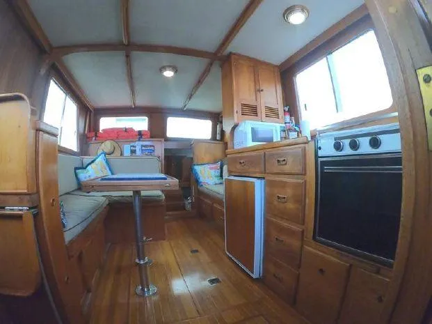 Slide: The Image of 1977 CHB 34 Double Cabin interior with wooden furnishings, kitchenette, and dining area. - 21