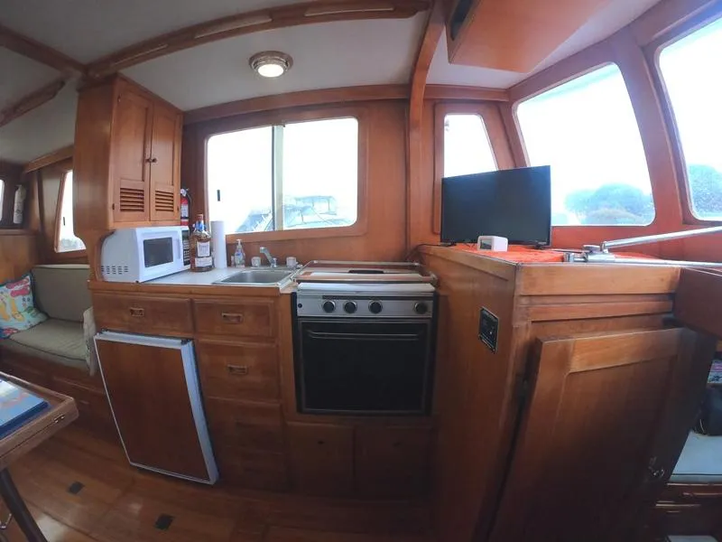 Slide: The Image of 1977 CHB 34 Double Cabin kitchen with wooden cabinetry, stove, microwave, and TV. - 3