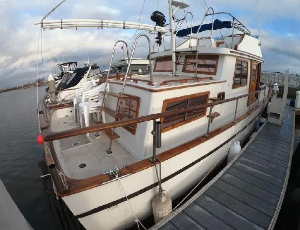 Slide: The Image of 1977 CHB 34 Double Cabin yacht docked at marina with wooden trim and white exterior. - 8