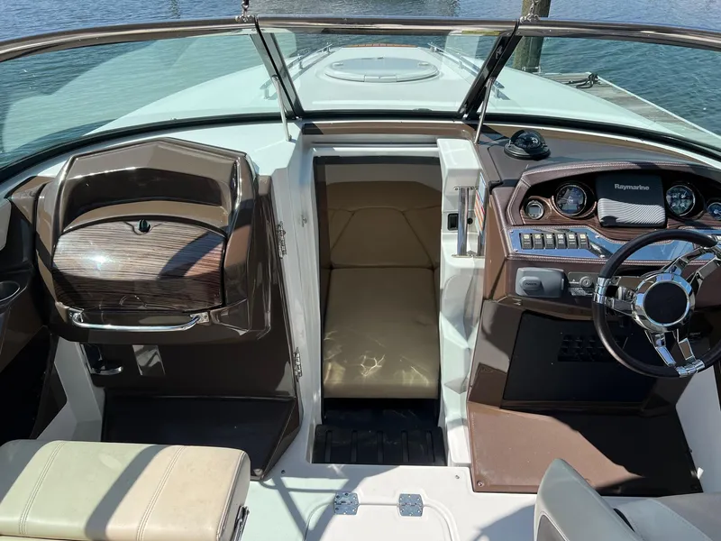 Slide: The Image of 2015 Monterey 268 SC boat interior with helm and cabin entrance. - 12