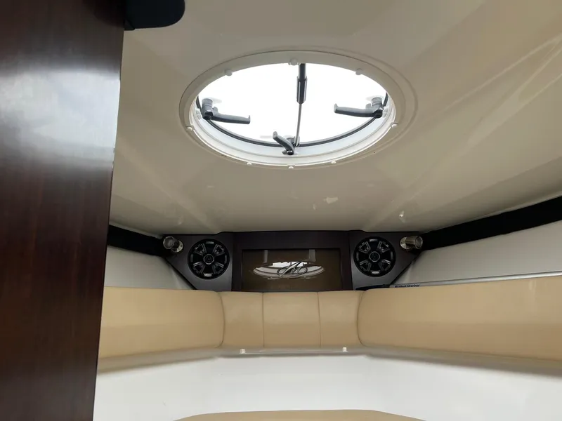 Slide: The Image of Interior cabin of 2015 Monterey 268 SC boat with round skylight and beige seating. - 15