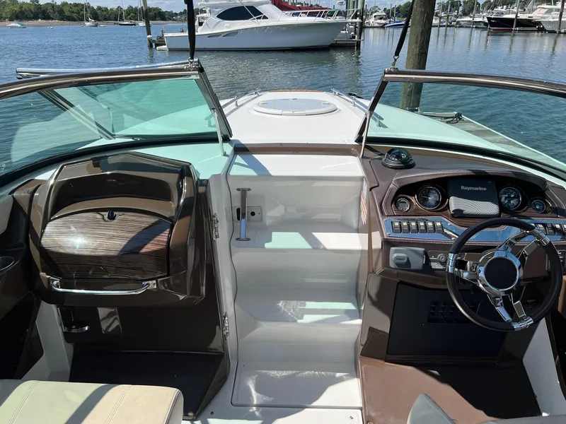 Slide: The Image of 2015 Monterey 268 SC boat interior with dashboard and steering wheel, docked at marina. - 16
