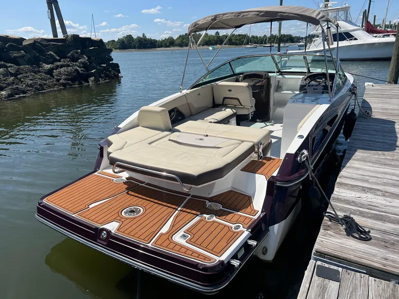 Slide: The Image of 2015 Monterey 268 SC boat docked, featuring a spacious deck and comfortable seating. - 2