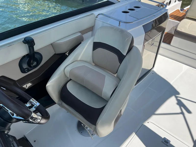 Slide: The Image of Captain's seat of a 2015 Monterey 268 SC boat with steering wheel and control panel. - 20