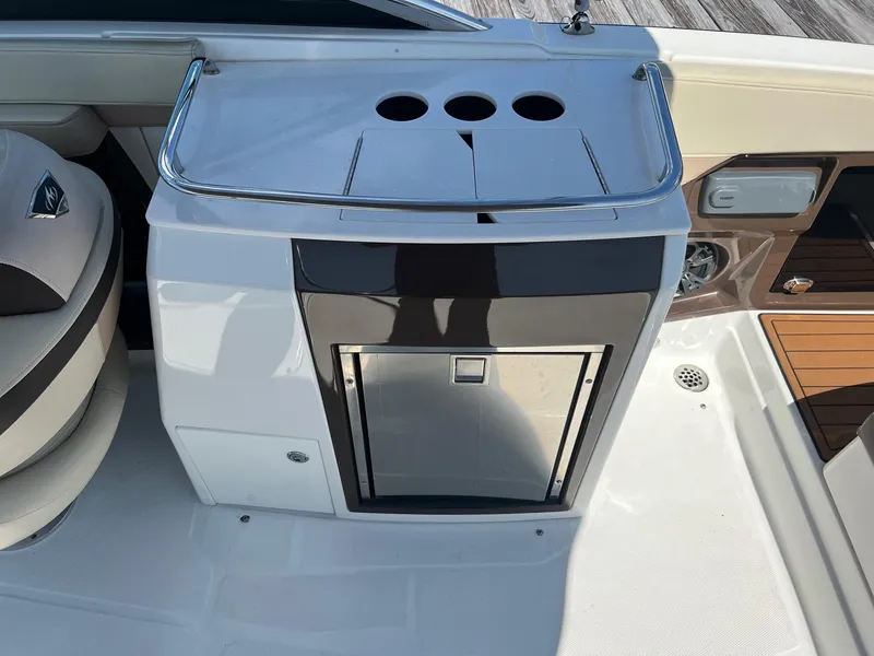 Slide: The Image of 2015 Monterey 268 SC boat interior with built-in cooler and cup holders. - 23