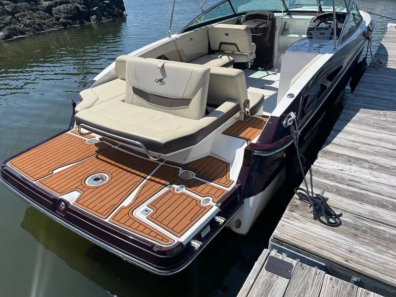 Slide: The Image of 2015 Monterey 268 SC boat docked, featuring spacious seating and teak swim platform. - 3