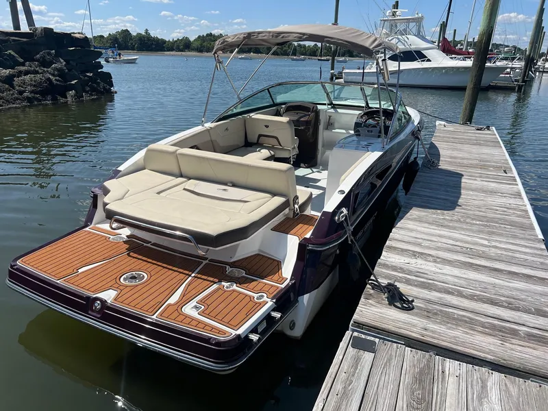 Slide: The Image of 2015 Monterey 268 SC boat docked at marina with tan upholstery and wooden deck. - 6