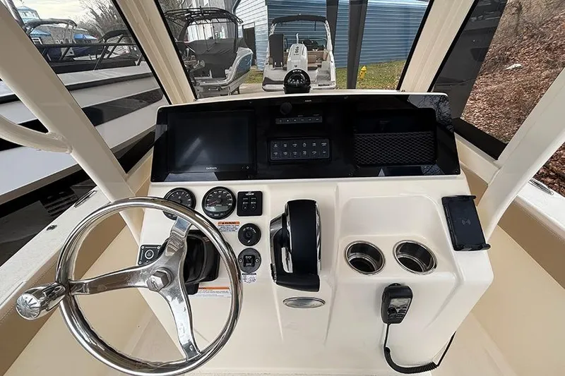 Slide: The Image of 2024 Scout 215 XSF boat dashboard with steering wheel and control panel. - 15