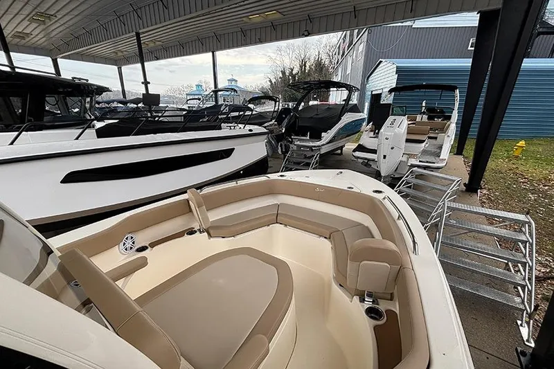 Slide: The Image of 2024 Scout 215 XSF boat displayed in a covered marina with other boats. - 16