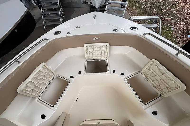 Slide: The Image of 2024 Scout 215 XSF boat interior with open storage compartments and seating. - 19