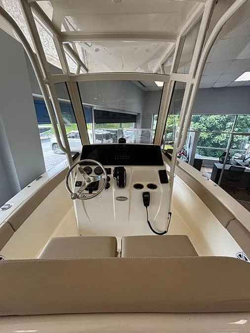 Slide: The Image of 2024 Scout 215 XSF boat interior with steering console and seating. - 2