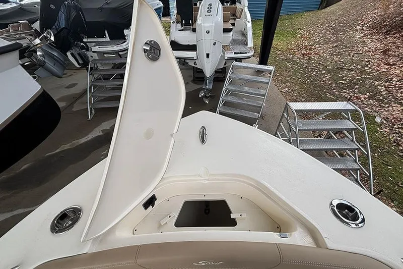 Slide: The Image of 2024 Scout 215 XSF boat with open storage compartment and visible outboard motor. - 20