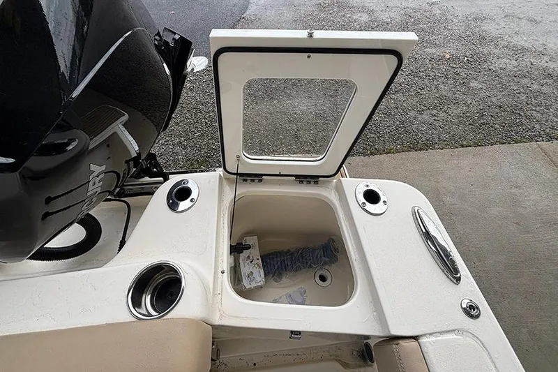 Slide: The Image of 2024 Scout 215 XSF boat with open storage compartment and Mercury engine. - 23