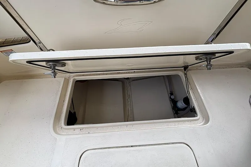 Slide: The Image of 2024 Scout 215 XSF boat storage compartment with open hatch, showcasing interior space. - 25