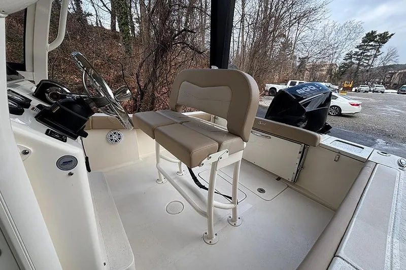 Slide: The Image of 2024 Scout 215 XSF boat interior with beige seating and steering wheel. - 26