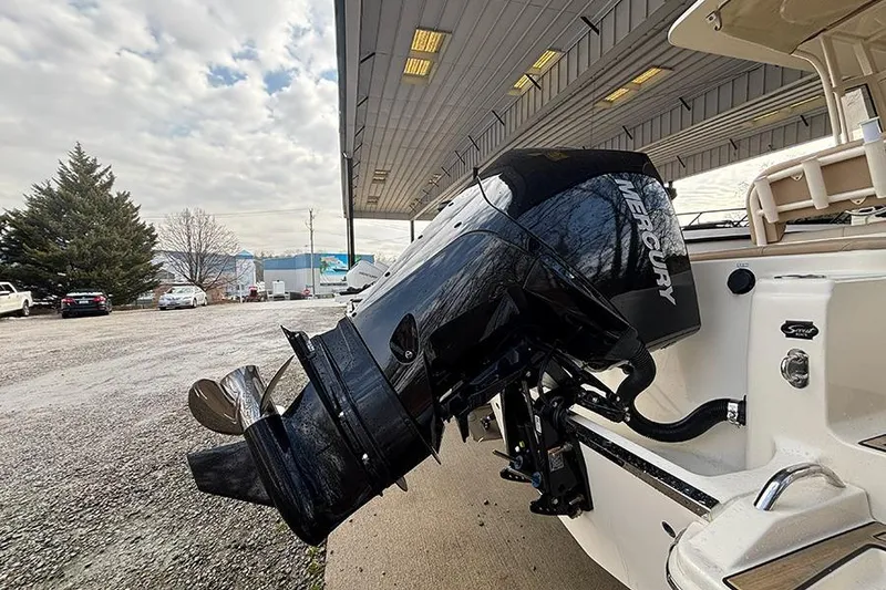 Slide: The Image of 2024 Scout 215 XSF boat with Mercury outboard motor under a covered area. - 27