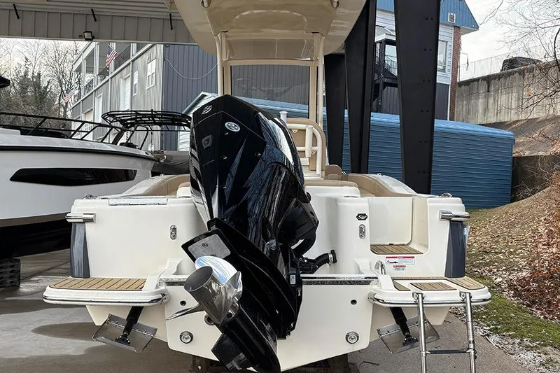 Slide: The Image of 2024 Scout 215 XSF boat with powerful outboard motor, docked under shelter. - 28