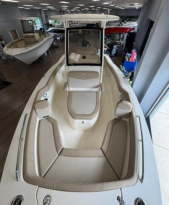 Slide: The Image of 2024 Scout 215 XSF boat interior with seating and console, displayed in a showroom. - 3