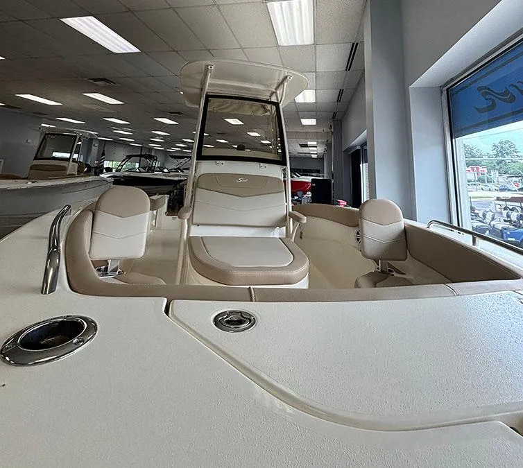 Slide: The Image of 2024 Scout 215 XSF boat interior with seating and helm station in showroom. - 4