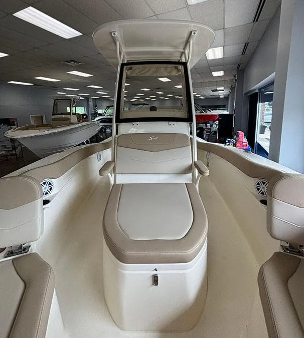 Slide: The Image of 2024 Scout 215 XSF boat interior with beige seating and center console. - 6