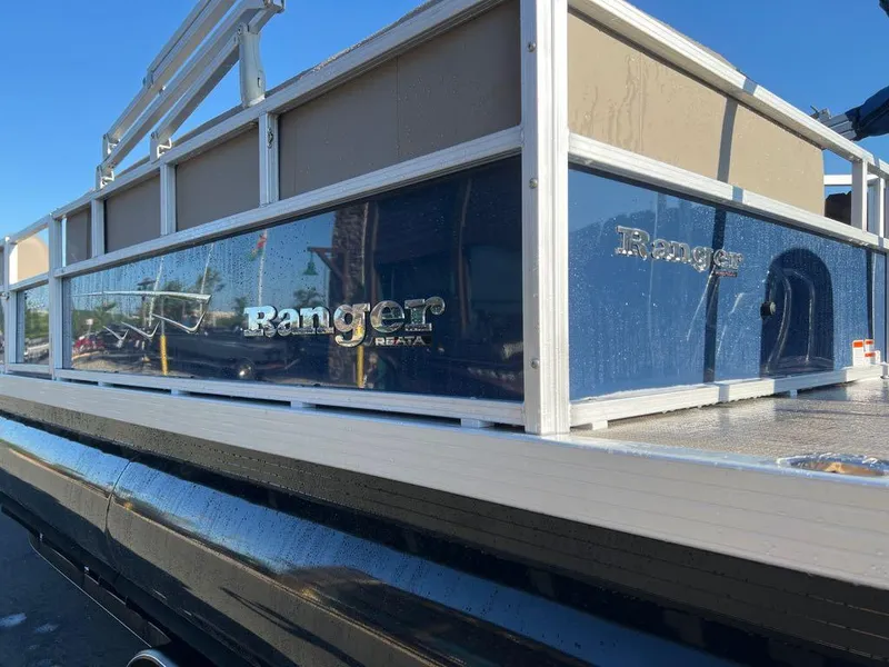 Slide: The Image of 2024 Ranger Reata 200C pontoon boat side view in sunlight. - 2