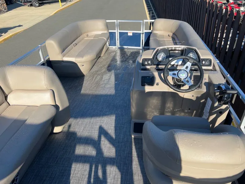 Slide: The Image of 2024 Ranger Reata 200C pontoon boat interior with beige seating and steering console. - 4
