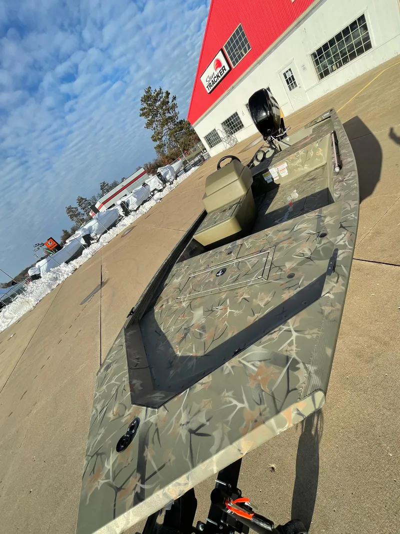 Slide: The Image of 2024 Tracker Grizzly 1648 SC boat in camouflage pattern outside dealership. - 4