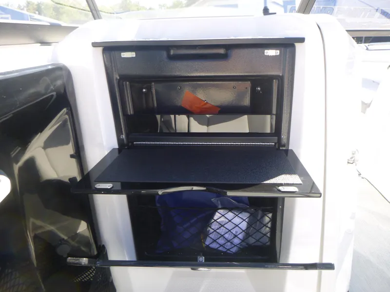 Slide: The Image of 2024 Yamaha Boats AR250 storage compartment with open shelves. - 19