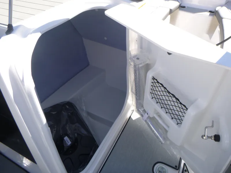 Slide: The Image of 2024 Yamaha Boats AR250 storage compartment with netted pocket and cushioned interior. - 24