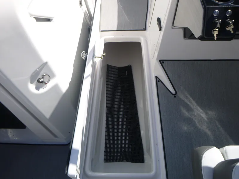 Slide: The Image of 2024 Yamaha Boats AR250 storage compartment with black mat. - 36