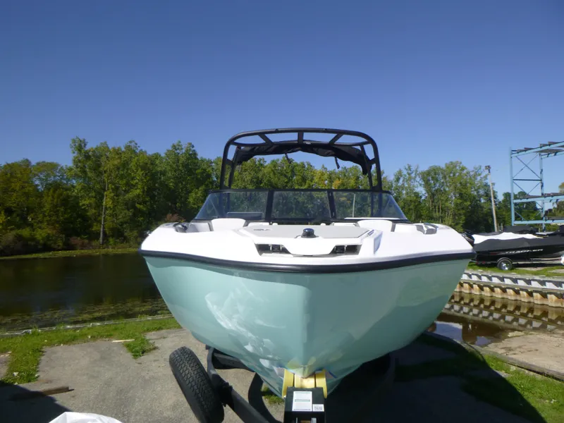 Slide: The Image of 2024 Yamaha Boats AR250 on trailer by a lake, front view. - 39