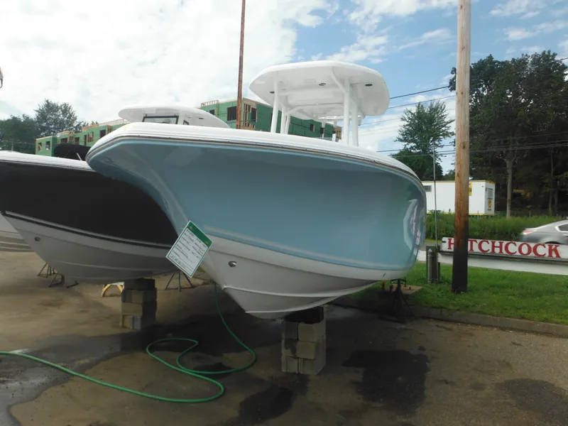 Slide: The Image of 2024 Tidewater 220 LXF boat on display, light blue hull, outdoor setting. - 2