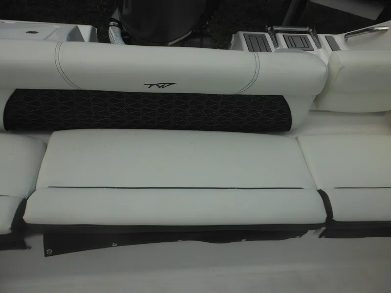Slide: The Image of 2024 Tidewater 220 LXF boat seating area with white cushions and black accents. - 20