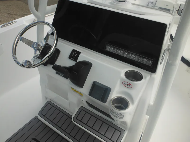 Slide: The Image of 2024 Tidewater 220 LXF boat console with steering wheel and cup holders. - 36