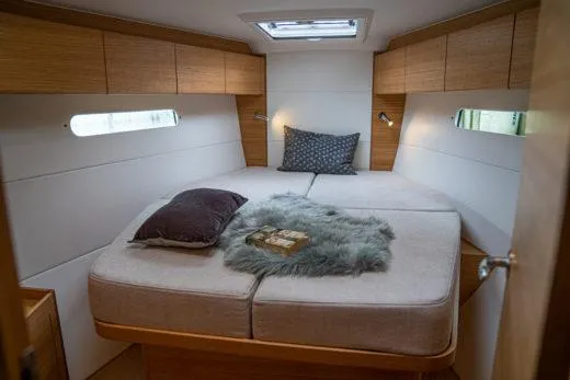 Slide: The Image of 2024 X-Yachts X4-0 yacht cabin with cozy bed, pillows, and modern lighting. - 17