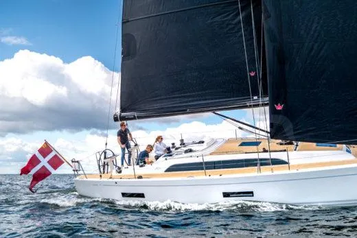 Slide: The Image of 2024 X-Yachts X4-0 sailing yacht with Danish flag on open water. - 2