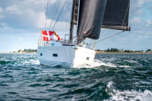 Slide: The Image of 2024 X-Yachts X4-0 sailing on open water with black sails. - 3