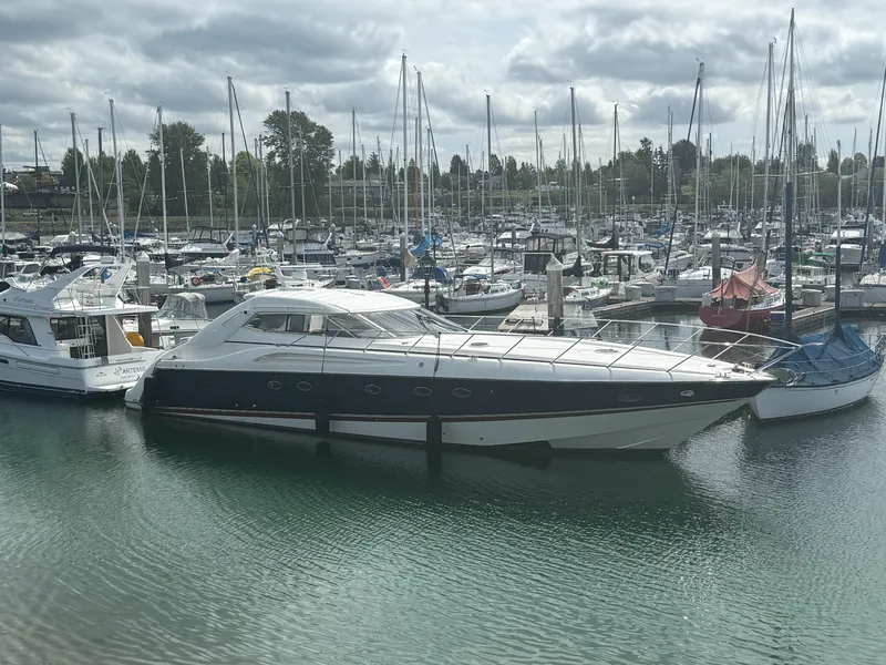 The Image of 1998 Sunseeker Predator 63 yacht docked in a marina, surrounded by other boats. - 0