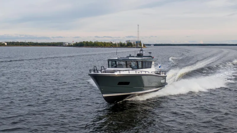 Slide: The Image of Sargo 45 Cat A 2025 motorboat cruising on a serene lake with forested shoreline. - 6