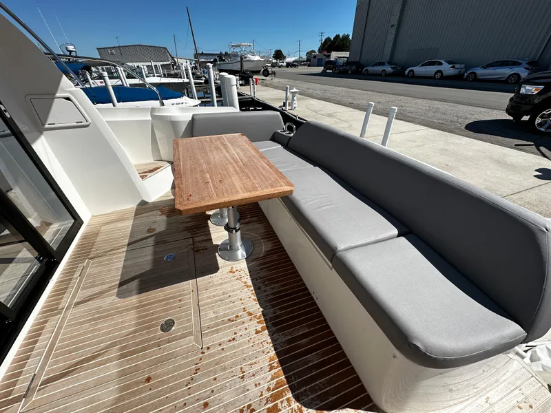 Slide: The Image of 2024 Prestige 420S yacht with outdoor seating and wooden table. - 19