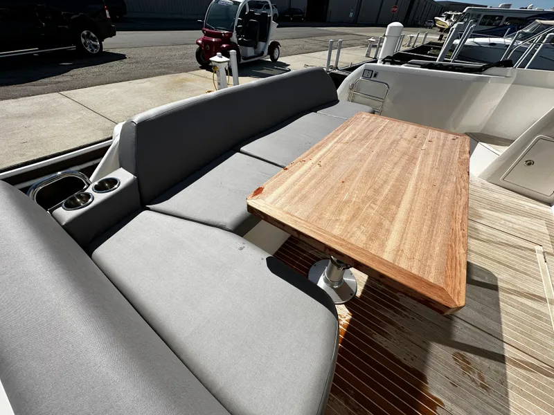 Slide: The Image of 2024 Prestige 420S yacht with outdoor seating and wooden table. - 22