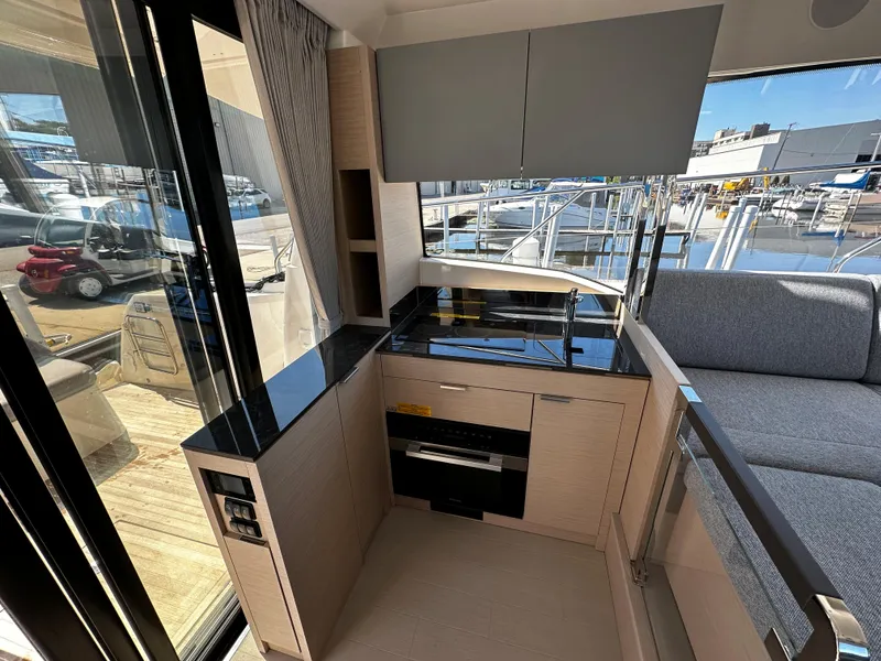 Slide: The Image of Modern kitchen area in 2024 Prestige 420S yacht with sleek cabinetry and waterfront view. - 27