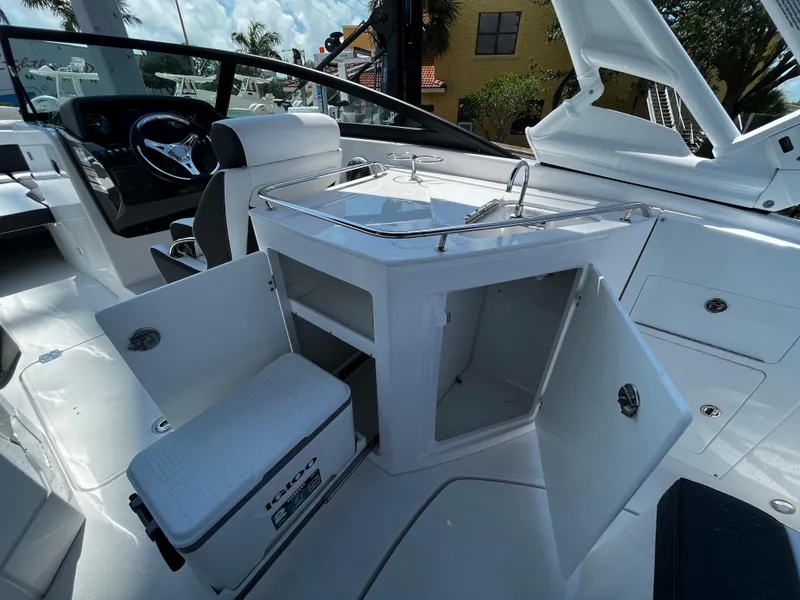 Slide: The Image of 2024 Monterey M-65 boat interior with open storage compartments and cooler. - 11