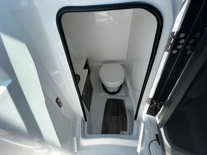 Slide: The Image of 2024 Monterey M-65 boat interior bathroom with toilet and storage. - 14